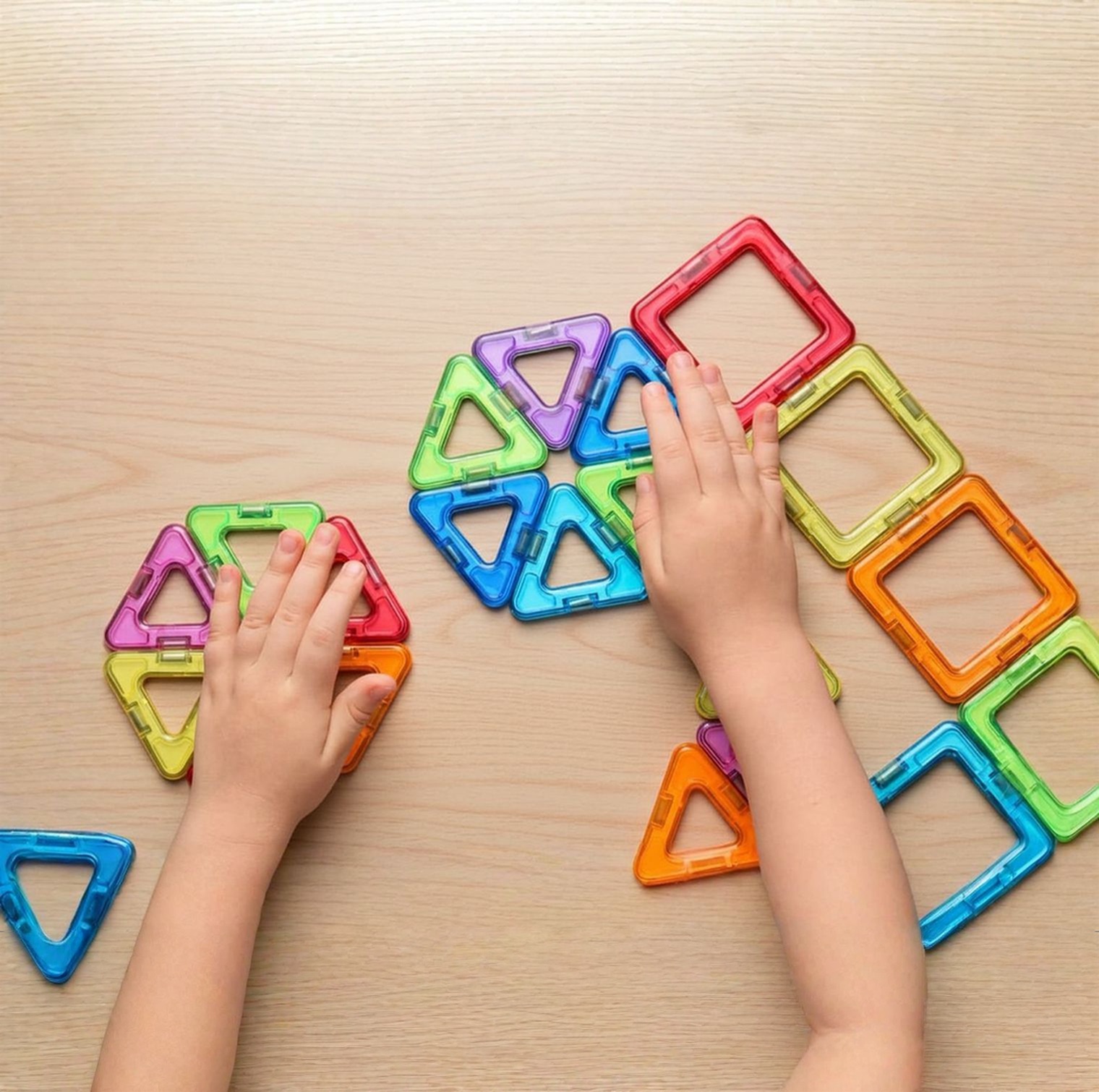 Child playing with colorful magnetic tiles